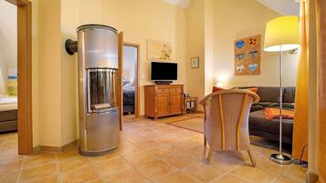 A living room with a sofa, a television, a cabinet, and a water dispenser.