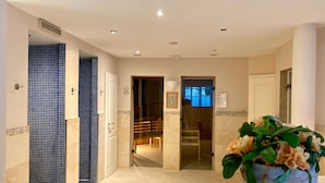 Un vestíbulo de hotel con pared de azulejos, mostrador de recepción y una planta en maceta.