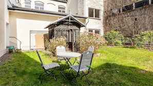 A courtyard with a gazebo, a table, and chairs. - Holiday Apartment in the Former Manor 'Bergblick' with Garden and Wi-Fi (Wurzbach)