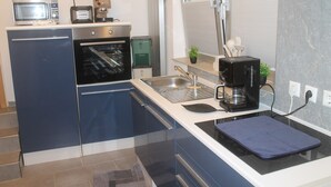 Una cocina moderna equipada con microondas, tostadora, cafetera y horno.