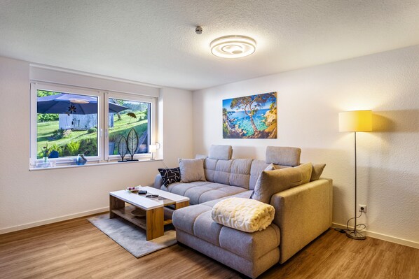 Un salon avec un canapé, une table basse, une lampe et un tableau au mur.