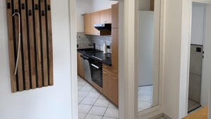 Una cocina moderna con armarios de madera, encimera negra y pileta de acero inoxidable.