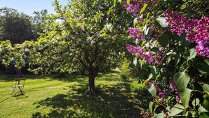 A garden with trees, grass, and a swing set. - Apartment '1' with Balcony and Wi-Fi (Heroldstatt)