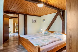 A wooden-framed room with a bed, a door, and a hallway leading to another room. - Apartment 'Nordwind' with Private Terrace, Shared Garden and Wi-Fi (Schülp)