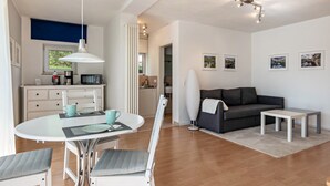 A modern living room with a dining area, a sofa, a coffee table, and a kitchen in the background. - Studio 'Jagst' with Shared Terrace and Wi-Fi (Michelbach an der Bilz)