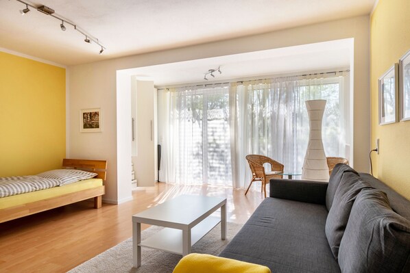 Un salon moderne avec un canapé, un lit, une table et une chaise.