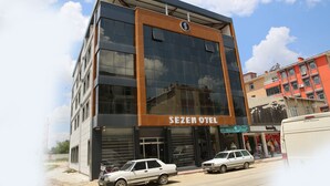 Egy modern szállodai épület, amelyen feltűnő felirat hirdeti: „SEZEN OTEL”.