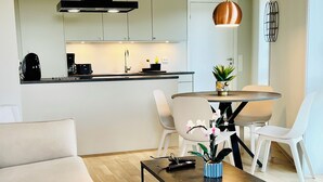 Un salon moderne comprenant un canapé, une table basse et un coin repas avec des chaises et une table.
