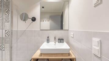 Ein Badezimmer mit Waschbecken, Spiegel und Handtuchhalter.