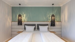 A double bed with white linens, a grey headboard, and two pendant lights. - Apartment at the old customs office (Deluxe) directly at Husum harbor (Husum)