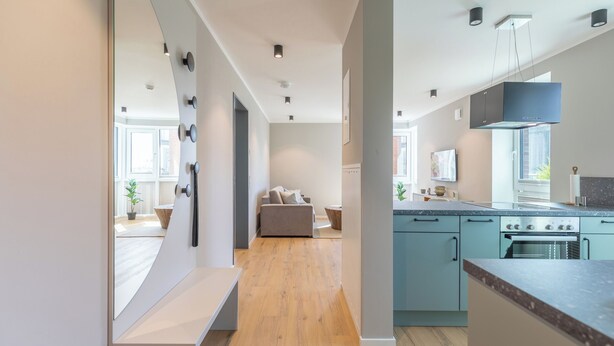 A modern kitchen with a central island, built-in appliances, and a view to the dining area. - Apartment Zollkoje 03 directly at the Husum harbor (Husum)