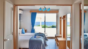 A hotel room with a balcony, a bed, a desk, and a wardrobe. - Ocean View Ishigaki Kaze & Nami (Ishigaki)