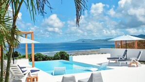 A pool area with lounge chairs and a view of the sea. - Ocean View Ishigaki Kaze & Nami (Ishigaki)