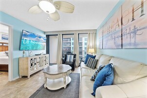 Condo com design assinado, 2 quartos, para não fumantes, sacada | Sala de estar | Smart TV 65 polegadas com canais a cabo