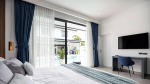 Une chambre moderne avec un grand lit, un bureau et une télévision.