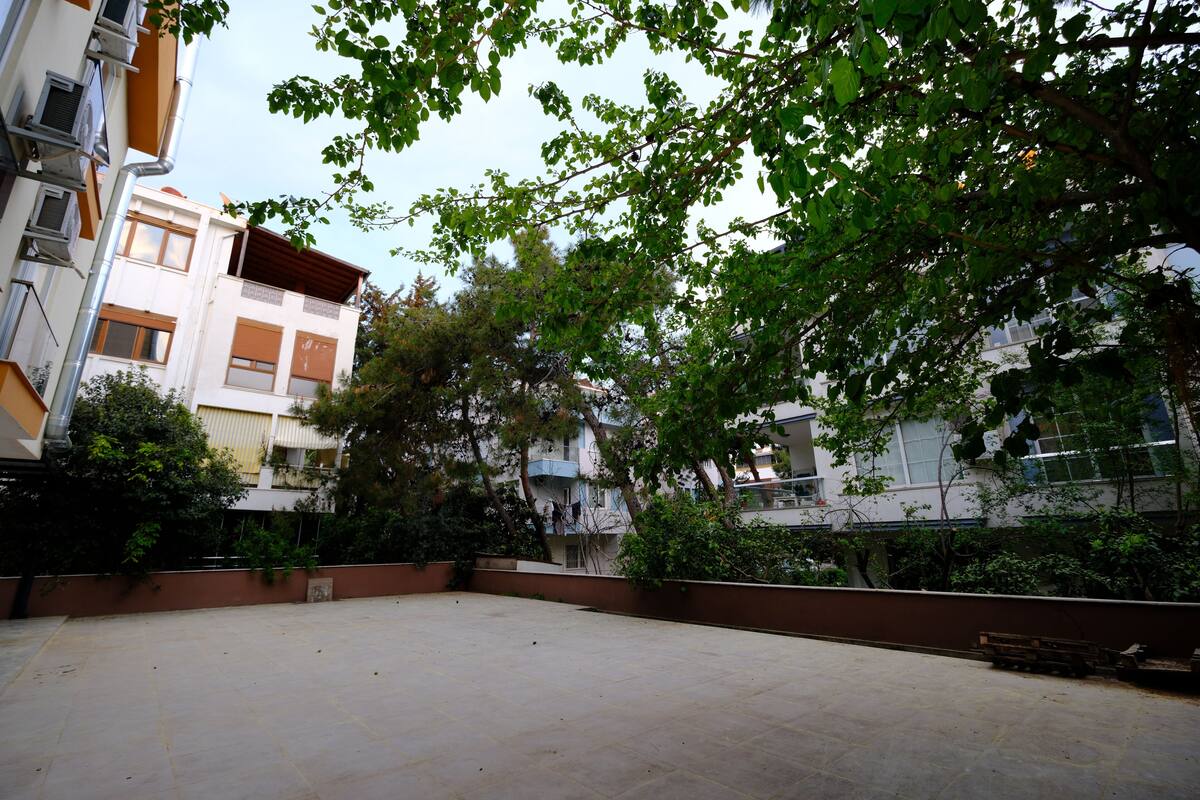 A courtyard with a tiled floor, surrounded by buildings with balconies and windows.