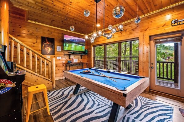 A wooden interior with a pool table, a billiards table, a pool table, a pool table, a pool table, a pool table, a pool table, a pool table, a pool table, a pool table, a pool table, a pool table, a pool table, a pool table, a pool table, a pool table, a pool table, a pool table, a pool table, a pool table, a pool table, a pool table, a pool table, a pool table, a pool table, a pool table, a pool table, a pool table, a pool table, a pool table, a pool table, a pool table, a pool table, a pool table, a pool table, a pool table, a pool table, a pool table, a pool table, a pool table, a pool table, a pool table, a pool table, a pool table, a pool table, a pool table, a pool table, a pool table, - Spacious 4BR Cabin Retreat w/ 2 Game Rooms, Double Wraparound Decks & Views (Pigeon Forge)