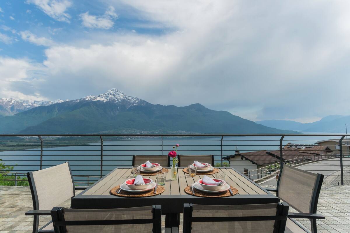 Une table dressée pour deux personnes, avec une vue sur les montagnes en arrière-plan.