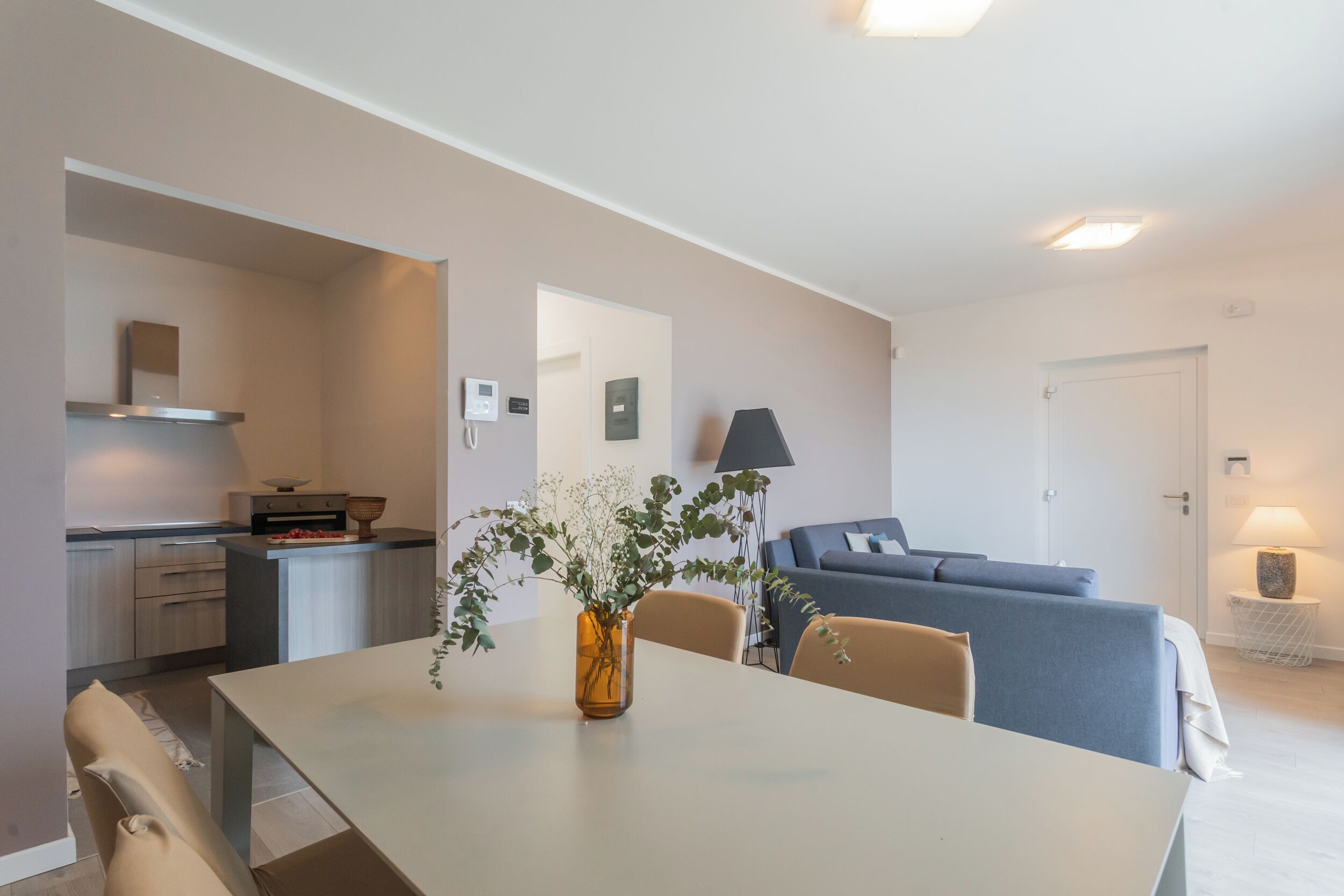 A modern living space with a dining area, kitchen, and seating area.