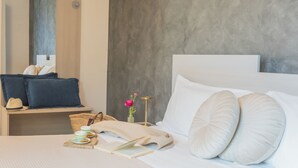 A neatly made bed with white pillows and a blue headboard, a bedside table with a lamp, a vase with flowers, and a basket. - Blooms by the Lake by Rent all Como (Trezzone)