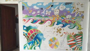 A colorful mural with abstract faces and patterns on a wall. - Nid bleu in Schoelcher: calm, escape, sea view, nature, beaches and amenities (Schoelcher)