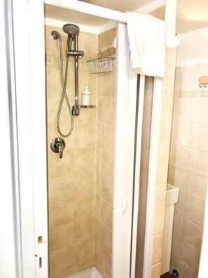 Enjoy a refreshing shower with a handheld showerhead and wall-mounted towel rack.