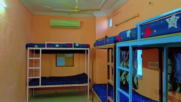 A room with bunk beds, an air conditioning unit, and a ceiling fan. - V Food Dormitory (Jodhpur)