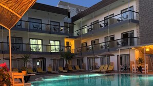 Ett hotell med en swimmingpool, utomhusplats och flera balkonger.