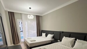 Ein Hotelzimmer mit zwei Betten, einem Schreibtisch und einem Fernseher.