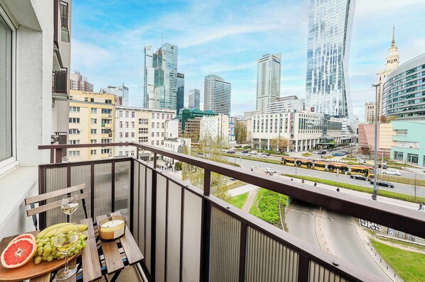 A balcony with a table, a fruit bowl, and a candle.