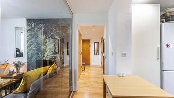 A modern kitchen with a wooden table and a refrigerator.