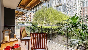 A balcony with wooden furniture, a candle, and a potted plant.