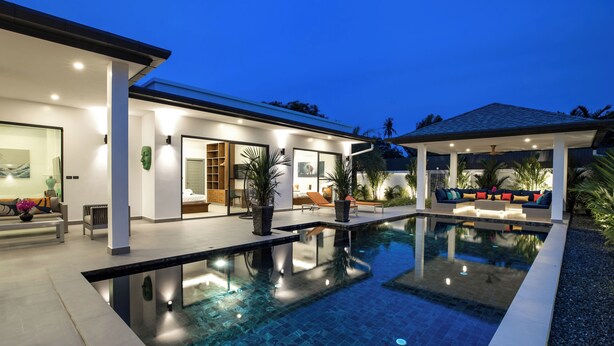 A modern house with a swimming pool, outdoor seating, and a covered patio area. - Luxurious 3 bedrooms pool villa at rawai (Tambon Rawai)