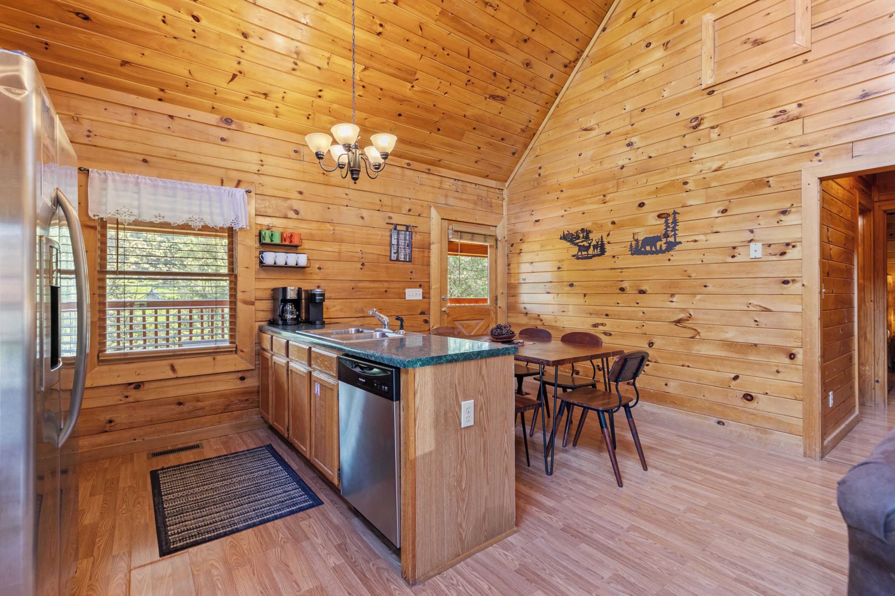 L’intérieur d’un chalet en bois comprend une cuisine, un coin repas et une grande fenêtre.