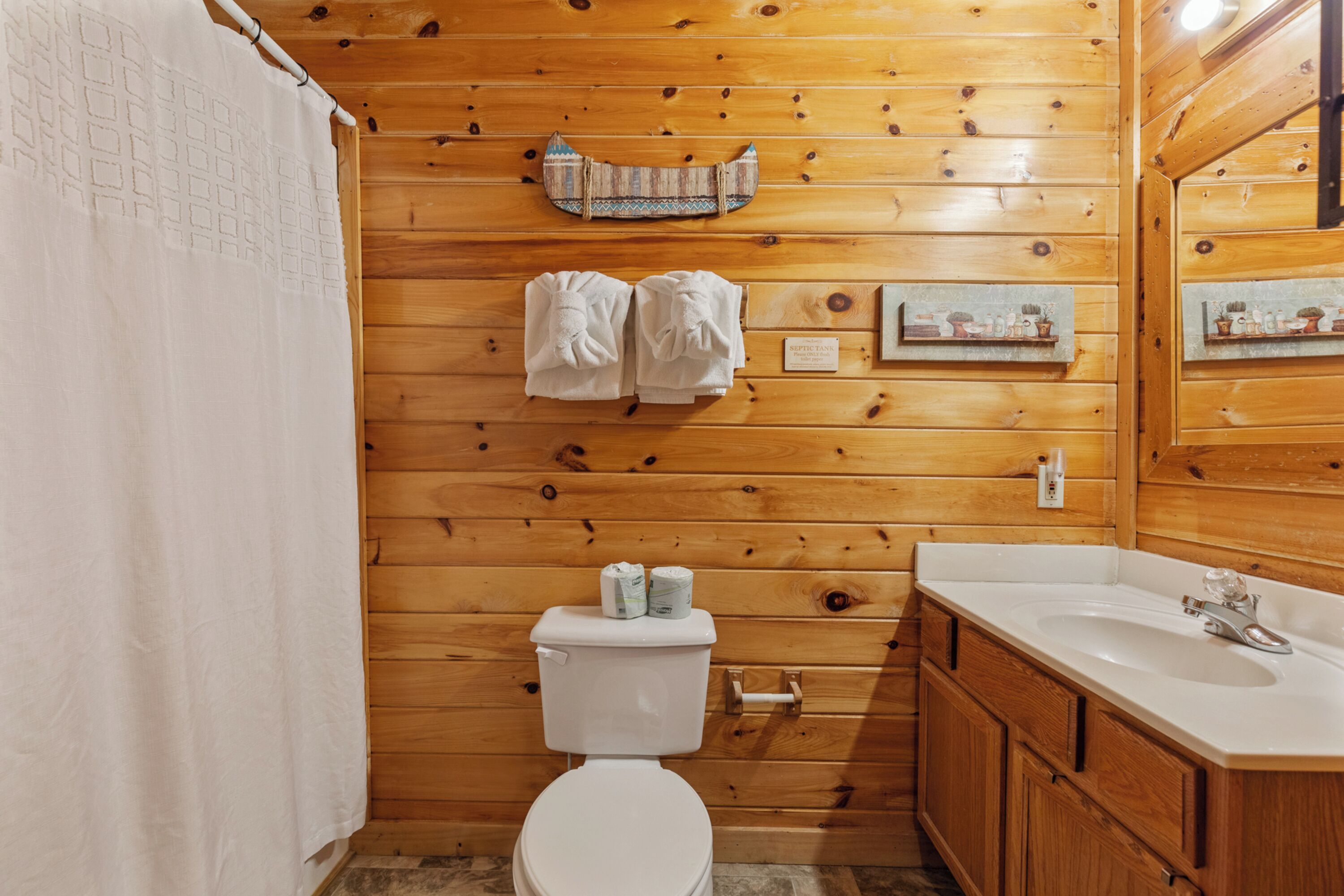 Un bagno con rivestimenti in legno, dotato di WC, lavabo e porta asciugamani.