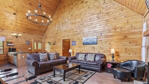A log cabin interior with a living room, kitchen, and dining area. - Serene Creek Cabin (Sevierville)