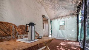 Un ambiente acogedor con una mesa de madera, una tetera y vasos, además de un amplio ventanal que deja entrar luz natural.