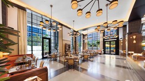 A spacious hotel lobby with multiple dining areas, large windows, and modern lighting fixtures. - 2BR Downtown Miami Condo | City Views | Pool (Miami)