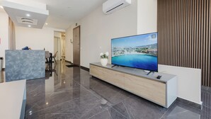 Eine moderne Hotellobby mit großem Flachbildfernseher, einer Rezeption und einer Wandpaneelausstattung aus Holz.