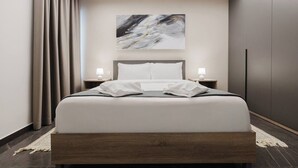 A modern hotel room with a large bed, two bedside tables with lamps, a ceiling light, a painting on the wall, and a wardrobe. - Enjoy a stylish experience at this centrally-located place. Enjoy easy access to Qawra promenade only seconds away from parks and the aquarium.  Modern and stylish, this apartment in Qawra is the ideal place to spend a holiday. (San Pawl il-Baħar)