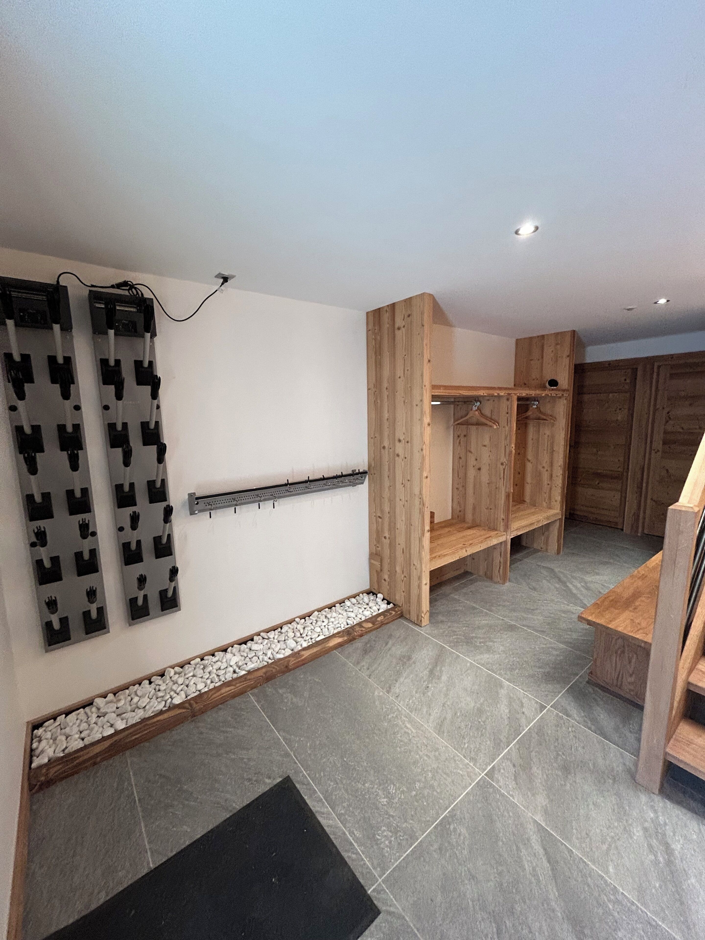 A modern bathroom with a shower, a wooden vanity, and a wall-mounted towel rack.