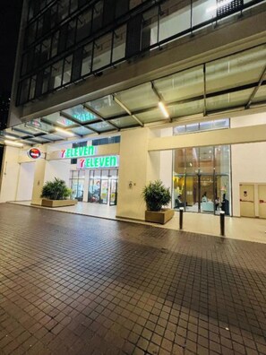 A 7-Eleven convenience store with a tiled entrance area and potted plants. - Family Suite Colony By Infinitum KLCC  (Kuala Lumpur)