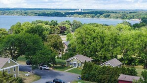 A residential area with houses, a driveway, and a lake in the background.