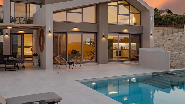 A modern two-story house with a swimming pool, outdoor seating, and large windows. - Kassiani Villa | Theo Luxury Villas With Sea View (Agia Marina)