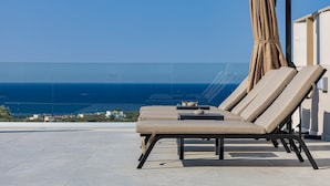 A rooftop terrace with lounge chairs and a view of the sea. - Kassiani Villa | Theo Luxury Villas With Sea View (Agia Marina)