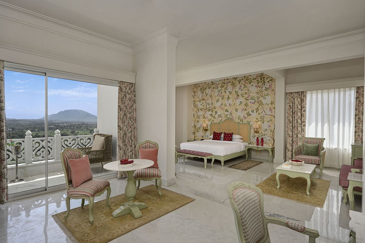 Un dormitorio amplio con una cama grande, un balcón con vistas y una decoración clásica.