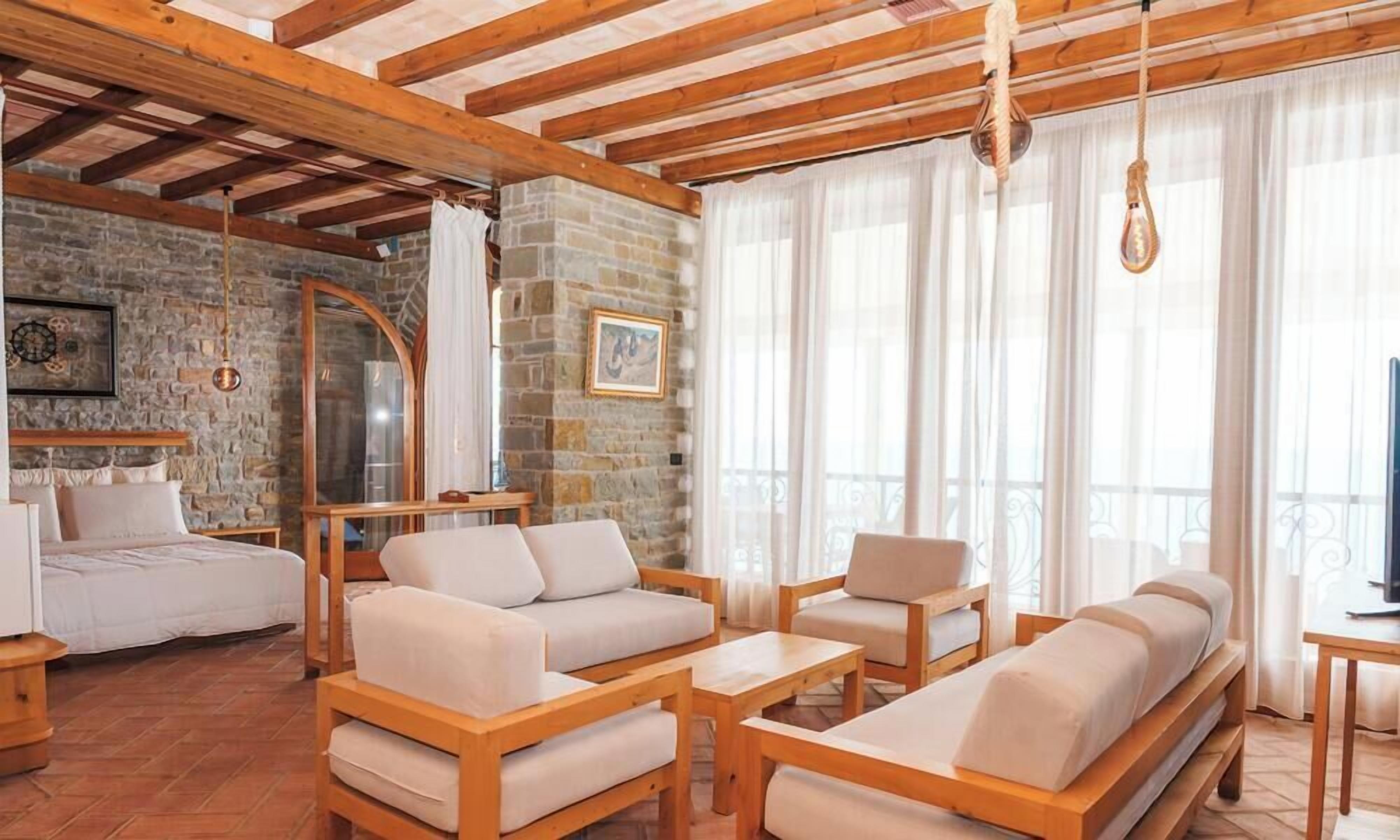 Une pièce chaleureuse avec un mur en pierre, des meubles en bois et un lit.