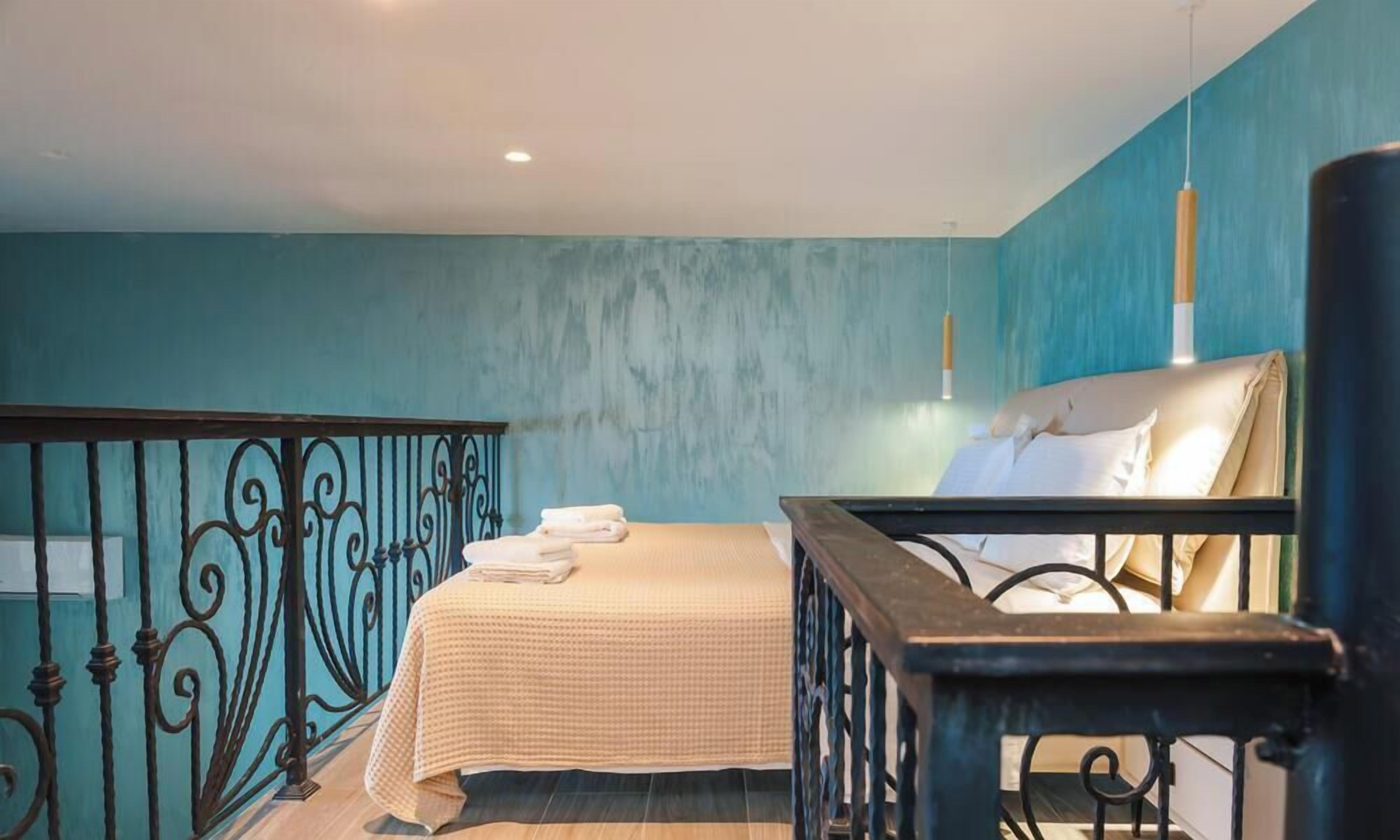 Une chambre à coucher avec un lit, une table de chevet, une fenêtre et une balustrade de balcon.