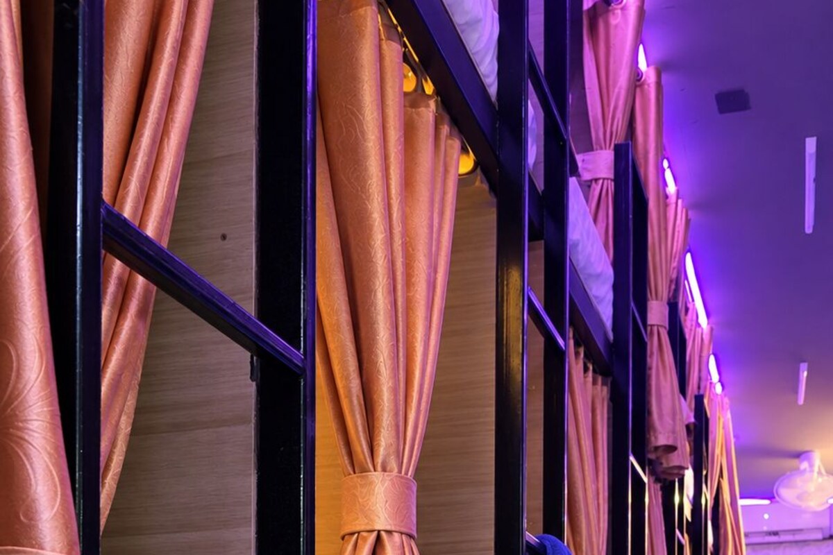 A hotel room with a bed, a wardrobe, and a mirror.