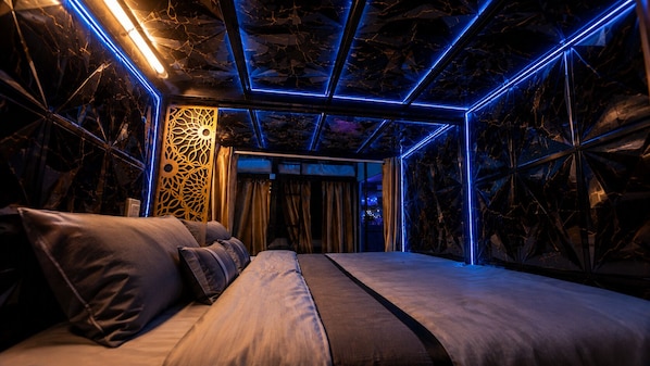A modern room with a bed, a decorative wall panel, and a geometric ceiling design. - Hangover Hostel Patong (Patong)